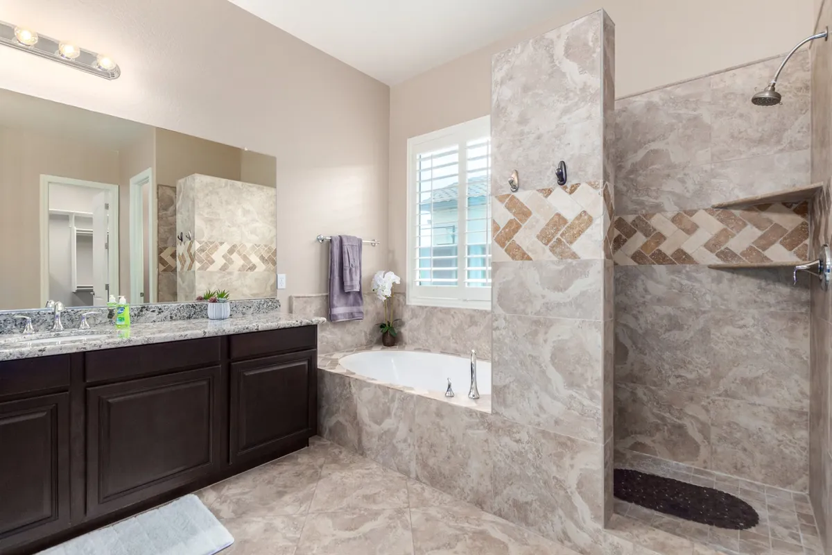 A spa-inspired bathroom with a sleek bathtub, separate shower area, and a vanity with a large mirror. The design is calming and modern, inviting relaxation and self-care.